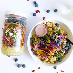Colorful salad with a jar of salad mix and dressing on a white background