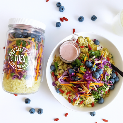Colorful salad with a jar of salad mix and dressing on a white background